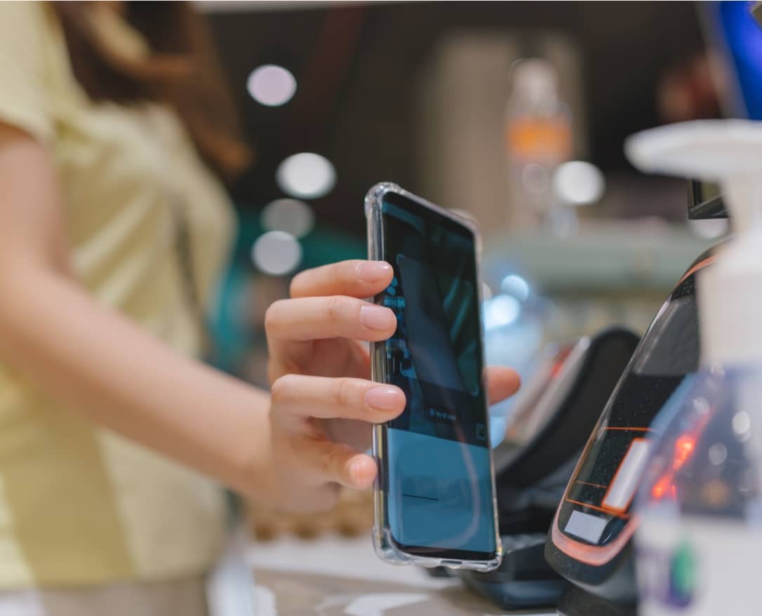 Photo of a person holding a phone up to a scanner